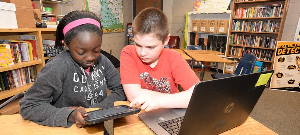 Two students looking at a tablet computer